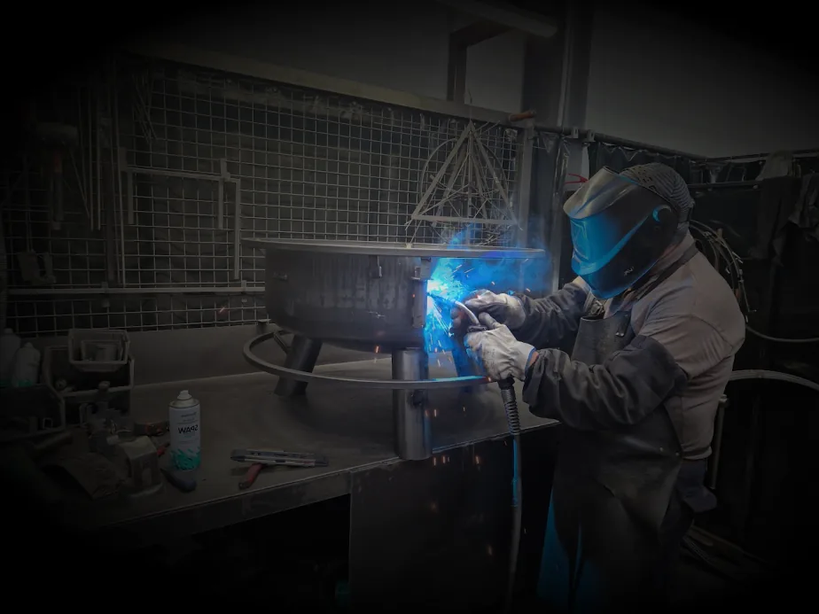 COOK KING welder welding a fire bowl in our workshop